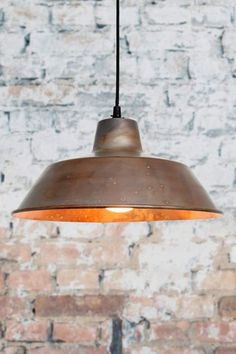 an industrial style light hanging from a brick wall