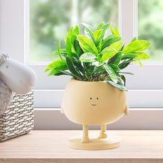 a potted plant sitting on top of a wooden table next to a stuffed animal