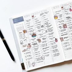 an open planner with stickers on it next to a pen