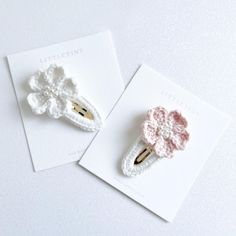 two crocheted hair clips sitting next to each other on top of a card