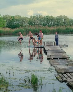 several children are playing in the water on a dock