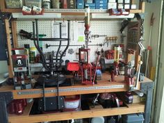 a workbench with tools and other items on the shelf in front of it