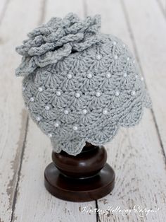 a crocheted hat on top of a wooden stand