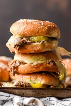 three hamburgers stacked on top of each other with meat and cheese in the middle