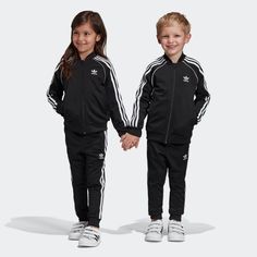 A TRICOT TRACKSUIT INSPIRED BY ARCHIVAL DESIGN Calling all future MVPs. Your star will win at sporty style in this toddler's track suit. Level up their Adidas game with iconic 3-Stripes and a hit of piping. That OG tricot sheen adds the finishing touch. This tracksuit is made with Primeblue, a high-performance recycled material made in part with Parley Ocean Plastic. More Details Regular fit Full zip with ribbed collar 100% recycled polyester tricot Soft feel Front welt pockets on jacket Raglan Toddler Adidas, Adidas Set, Tricot Fabric, Suit Black, Adidas Kids, Adidas Girl, Track Suit, Adidas Shop, How To Hem Pants