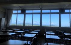 an empty classroom with many desks and large windows