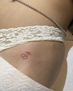 a woman's stomach with a small tattoo on the lower part of her belly