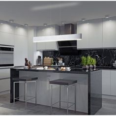 a modern kitchen with marble counter tops and stainless steel appliances, along with two stools