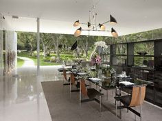 a modern dining room with glass table, chairs and an open area to the outside