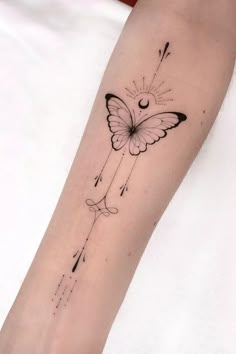 a small butterfly tattoo on the arm with arrows and stars coming out of its wings