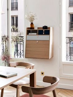 a room with a table, chairs and a book shelf in the middle of it