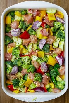 a casserole dish with broccoli, red onions, and other vegetables