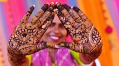 a woman holding her hands up to show the hendi