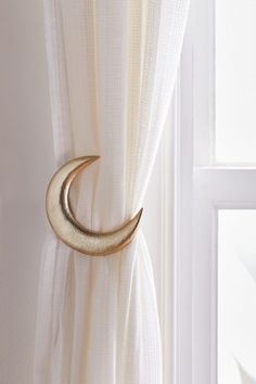 a curtain with a gold crescent hanging on it's side next to a window