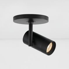 a black track light on a white background with the lights turned on and one arm down