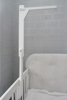 a white crib in a room with brick walls