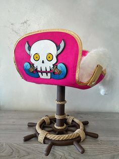 a pink chair with a skull on the back and rope around it's legs