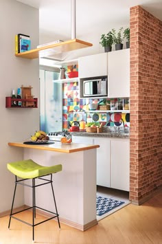 a kitchen with a brick wall and colorful tiles on the backs splashing onto the floor