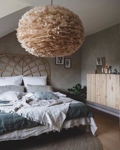 a bedroom with a bed, rug and hanging light fixture in the middle of it