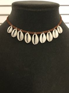 "Hawaii Cowrie shell leather choker necklace. Finished with a silver plated lobster clasp. Choker measures 14\". This is a great necklace to finish the Moana costume. A different length may be sketched upon check out. Warning: Choking hazzard. Not suitable for children 4 years and under. Due to the unique nature of natural shells, each order may vary slightly in appearance. Made in Hawaii." Adjustable Festival Choker With Lobster Clasp, Handmade Brown Choker For Beach, White Adjustable Choker With Lobster Clasp, Adjustable White Choker With Lobster Clasp, Moana Jewelry, Seashell Necklace Diy, Moana Necklace, Leather Choker Necklace, Seashell Necklace