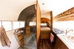 the inside of a camper with sink, stove and kitchen area in front of it