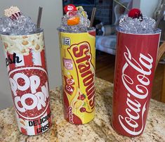 three different types of soda cans sitting on top of a counter