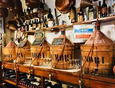 several wooden buckets filled with wine on top of a shelf