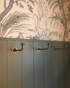 the bathroom is decorated with wallpaper and metal handles