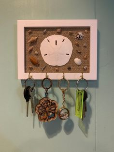 there is a clock and keys hanging on the wall with other key holders attached to it