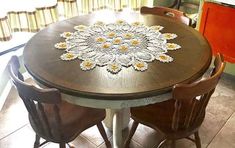 a table with chairs and a doily on it in the middle of a kitchen