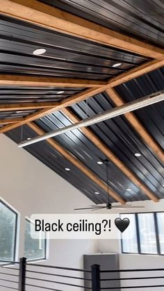 an empty room with black ceilings and metal bars on the ceiling is pictured in this image