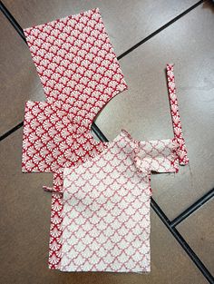 three pieces of fabric sitting on the floor next to each other with one piece cut out