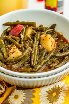 a white bowl filled with green beans and potatoes