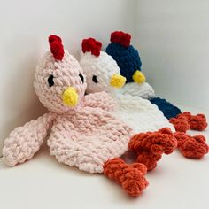 three crocheted stuffed animals sitting next to each other on a white table top