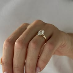 a woman's hand with a diamond ring on it