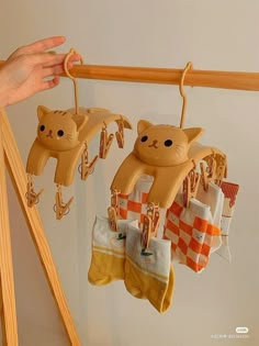 a person is holding up some socks with cats hanging from them on the clothesline