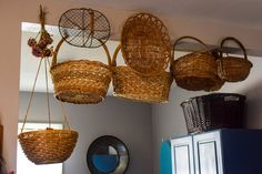 wicker baskets hanging from the ceiling in a kitchen