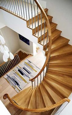 a spiral staircase with wooden handrails in a house