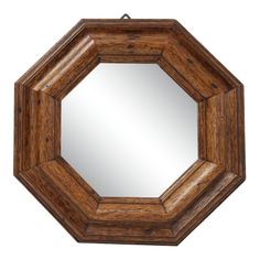 an octagonal wooden mirror hanging on a wall with a metal hook in the middle and wood frame around it