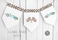 garland with cars and checkered flags hanging from it's sides on a white wooden background