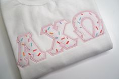 a white t - shirt with the word mary written in sprinkles