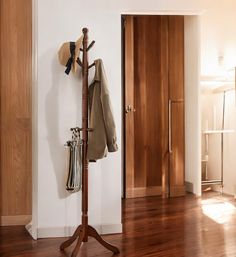 a coat rack with hats and purses on it next to a door in a room