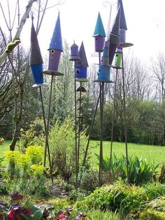 several colorful bird houses are in the garden