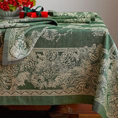 a green table cloth with pine cones on it