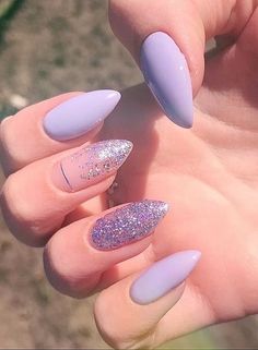 someone is holding up their hand with purple and silver nails