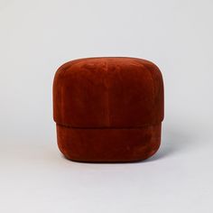 an orange ottoman sitting on top of a white floor