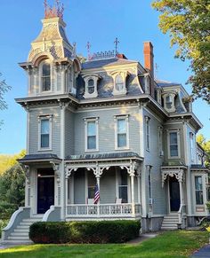 a large gray house sitting on top of a lush green field