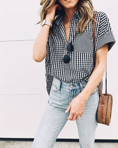 a woman wearing jeans and a checkered shirt