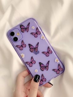 a woman's hand holding a purple phone case with butterflies on it