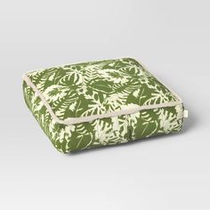 a green and white blanket with leaves on it